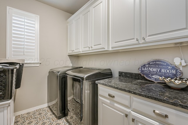 laundry area with cabinets, light tile patterned floors, and washer and clothes dryer