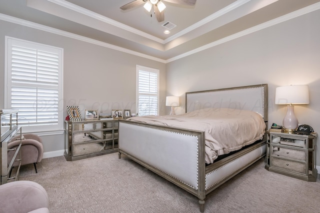 bedroom with a raised ceiling, ceiling fan, light colored carpet, and ornamental molding