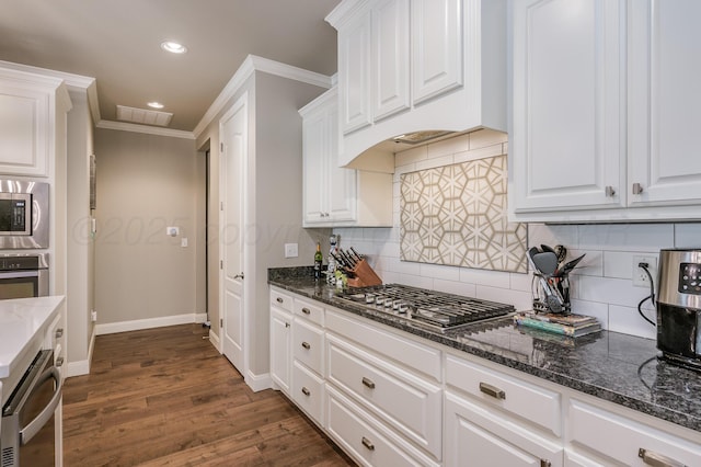 kitchen featuring white cabinets, backsplash, stainless steel appliances, and ornamental molding