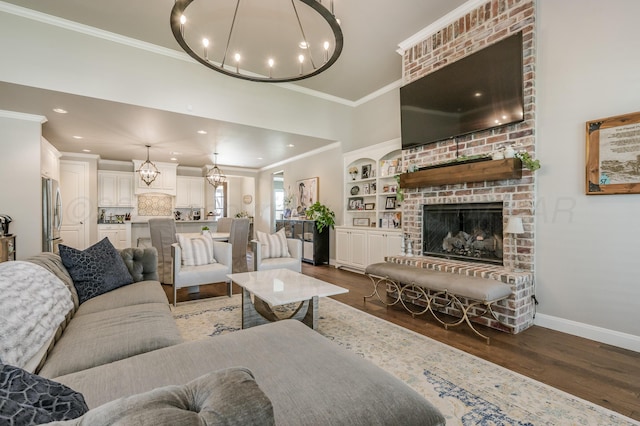 living room with built in shelves, crown molding, dark wood-type flooring, and a brick fireplace