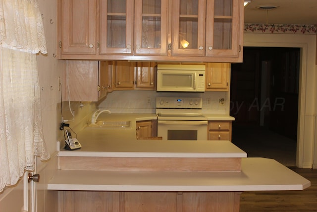 kitchen featuring kitchen peninsula, white appliances, and sink