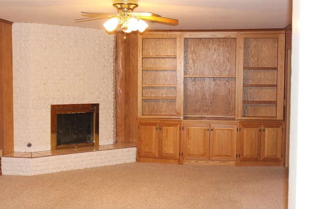 unfurnished living room with a fireplace, carpet floors, and ceiling fan