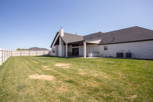 9800 Barton Springs Dr, Amarillo, TX 79119 - back of property featuring central air condition unit, a patio, brick siding, and a chimney