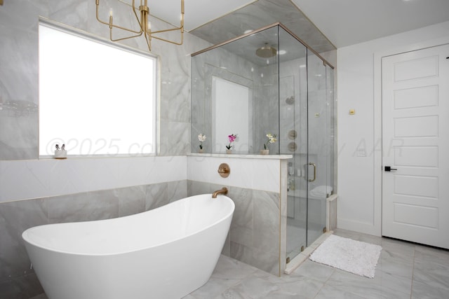 9800 Barton Springs Dr, Amarillo, TX 79119 - full bath featuring a shower stall, marble finish floors, a freestanding bath, a chandelier, and tile walls