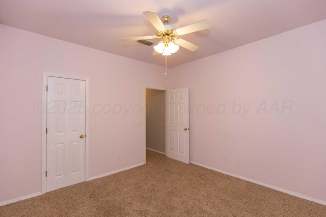 unfurnished room with carpet, a ceiling fan, visible vents, and baseboards