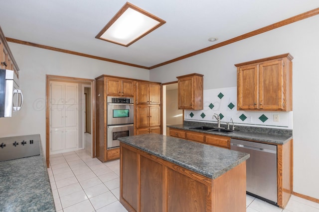 kitchen with dark countertops, tasteful backsplash, a center island, stainless steel appliances, and a sink