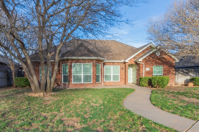 single story home featuring brick siding and a front yard