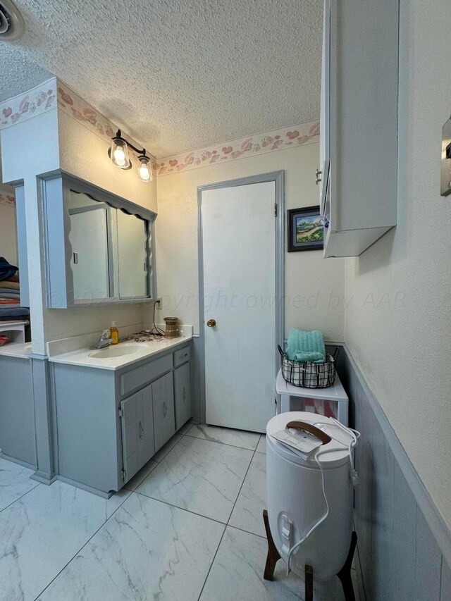 7204 SW 39th Ave, Amarillo, TX 79109 - bathroom with a textured ceiling, marble look tile flooring, and vanity