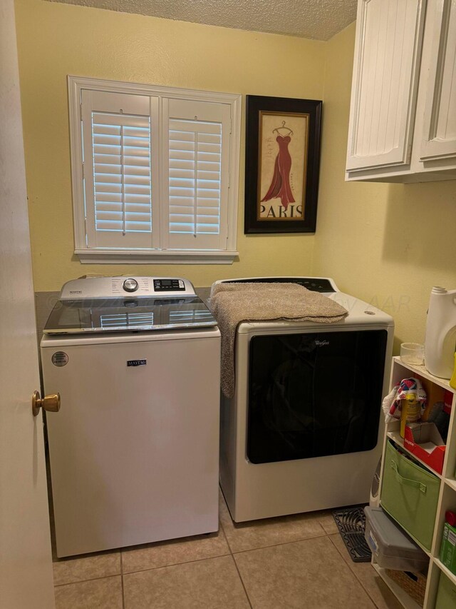 7204 SW 39th Ave, Amarillo, TX 79109 - laundry area with cabinet space, washing machine and clothes dryer, light tile patterned flooring, and a textured ceiling