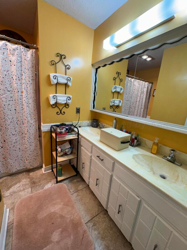 7204 SW 39th Ave, Amarillo, TX 79109 - bathroom featuring double vanity, tile patterned floors, curtained shower, and a textured ceiling