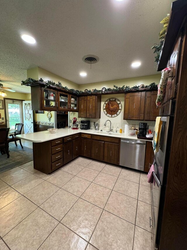 7204 SW 39th Ave, Amarillo, TX 79109 - kitchen with appliances with stainless steel finishes, a peninsula, dark brown cabinets, recessed lighting, and a textured ceiling