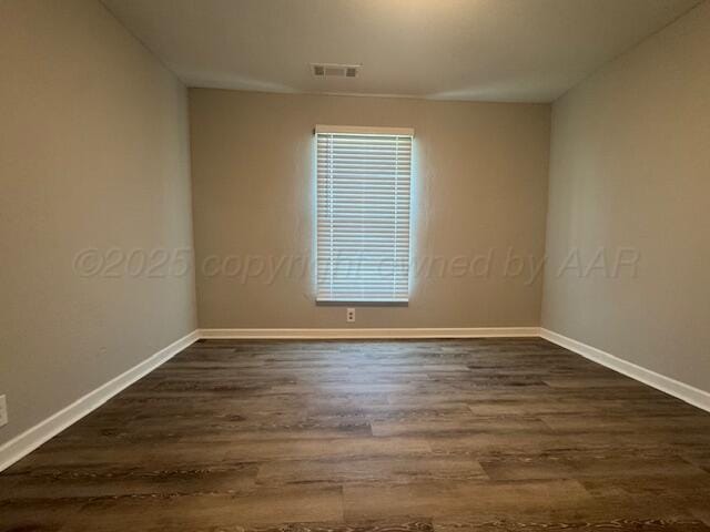 1602 N Hughes St, Amarillo, TX 79107 - spare room featuring dark wood-style flooring and baseboards