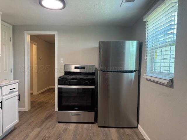 1602 N Hughes St, Amarillo, TX 79107 - kitchen featuring stainless steel appliances, white cabinets, light wood-style floors, and light countertops
