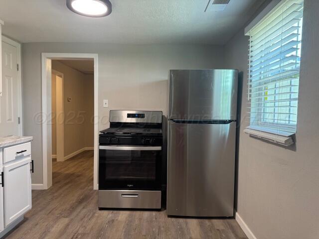 1602 N Hughes St, Amarillo, TX 79107 - kitchen featuring stainless steel appliances, white cabinets, light wood-style floors, and light countertops