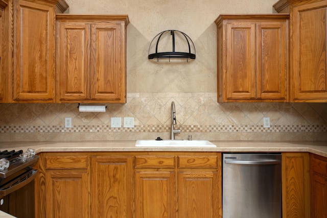 kitchen with range with gas stovetop, a sink, light countertops, dishwasher, and brown cabinets