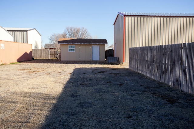 view of yard with an outbuilding, a storage shed, and fence