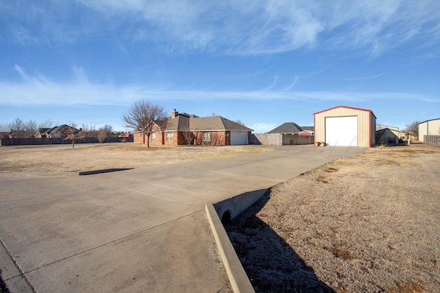 view of yard with driveway, an outdoor structure, a garage, and fence