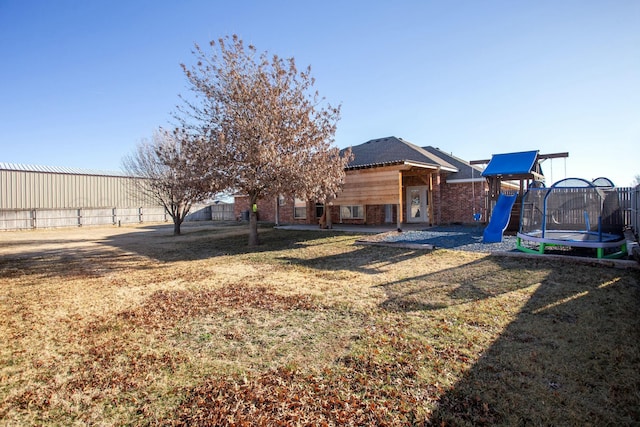 view of yard featuring a trampoline and fence