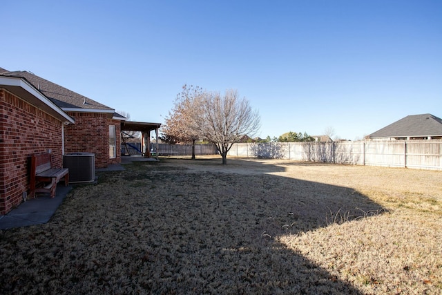 view of yard featuring central AC and a fenced backyard