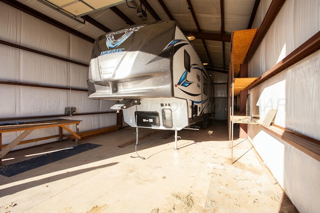 misc room with metal wall, a garage, and concrete floors