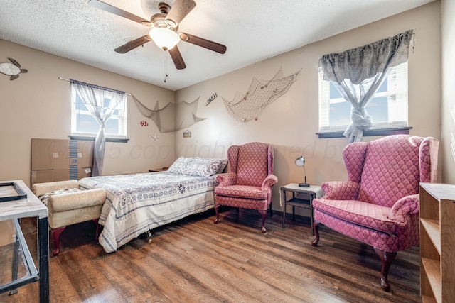 bedroom with a textured ceiling, a ceiling fan, and wood finished floors