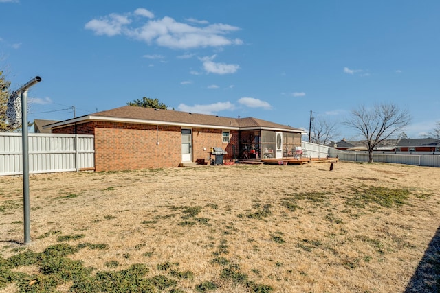 rear view of property with brick siding and a fenced backyard