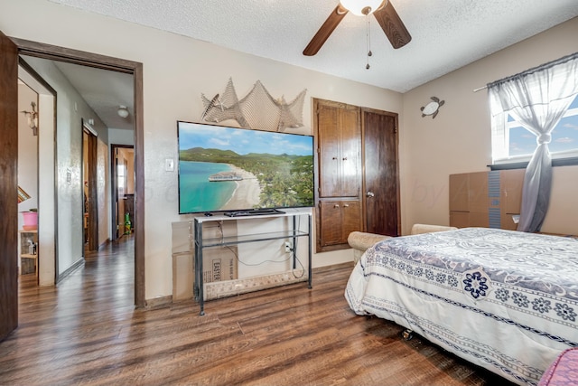 bedroom featuring a textured ceiling, ceiling fan, a closet, and wood finished floors