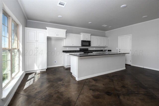 kitchen featuring black appliances, a center island with sink, a healthy amount of sunlight, and white cabinets