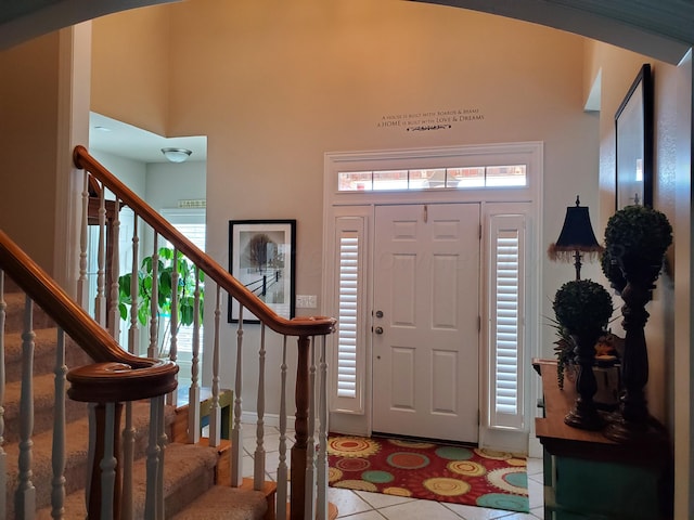 foyer entrance with light tile patterned floors and a high ceiling