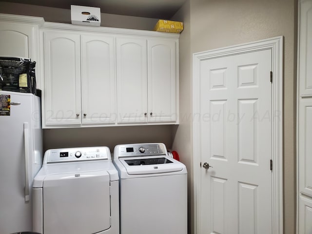 clothes washing area featuring cabinets and washer and dryer