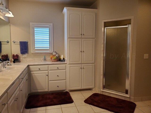 bathroom featuring vanity, tile patterned floors, and a shower with door