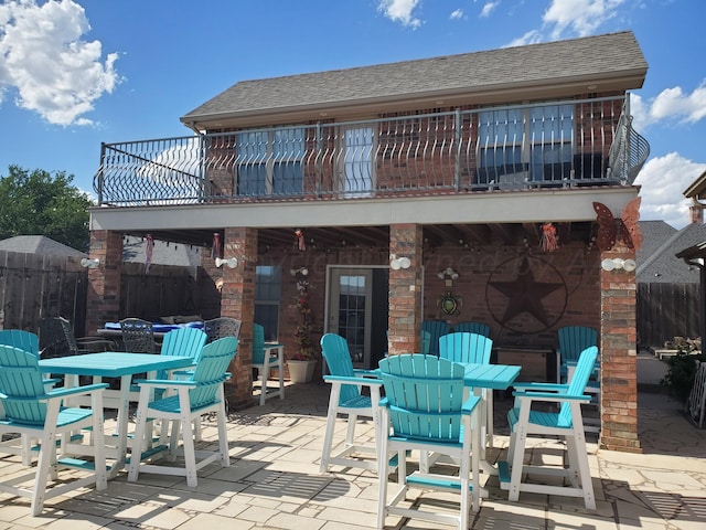 rear view of house with a patio and a balcony