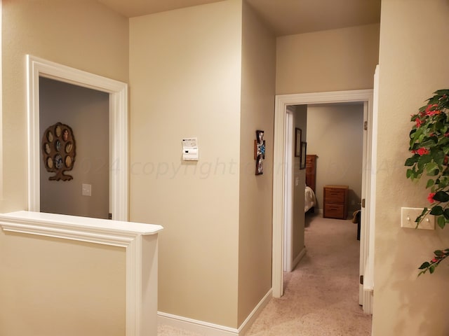 hallway featuring light colored carpet