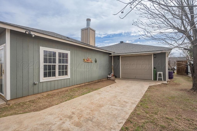 exterior space featuring driveway, a shingled roof, a chimney, and an attached garage