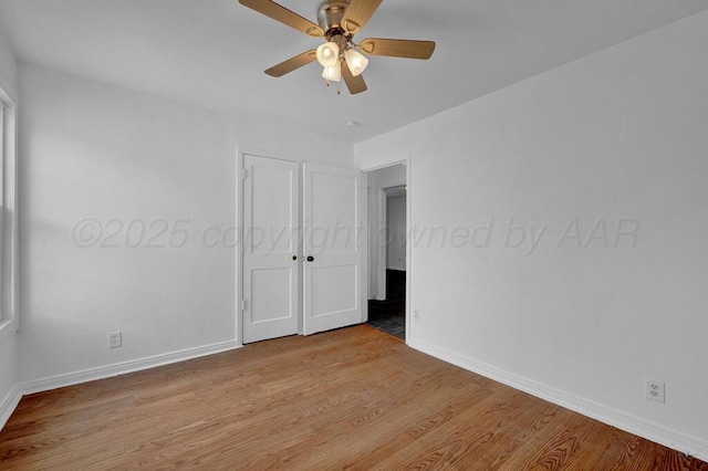 unfurnished room featuring ceiling fan, light wood-style flooring, and baseboards