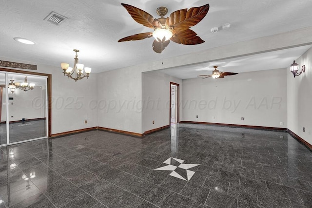 empty room featuring granite finish floor, visible vents, baseboards, and ceiling fan with notable chandelier