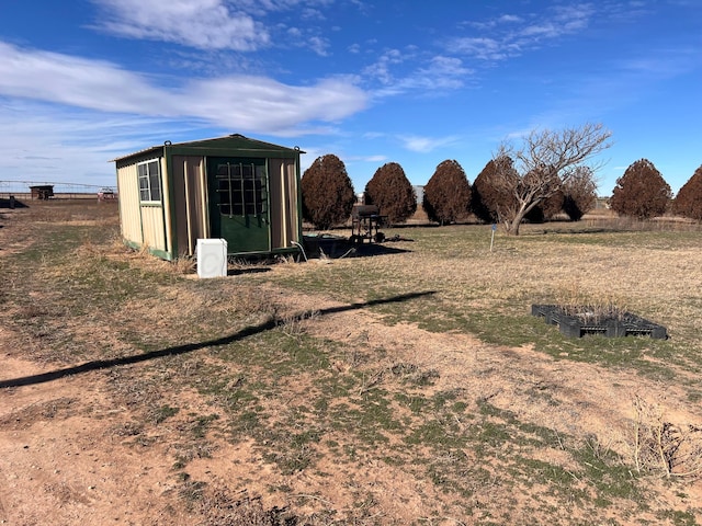 view of yard featuring a rural view and a shed