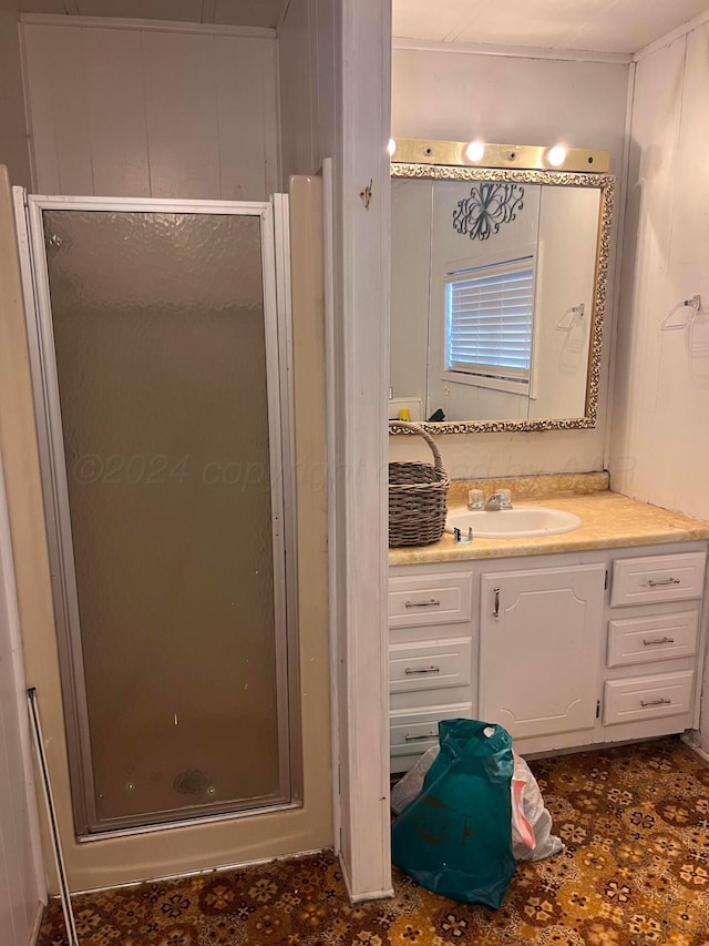 bathroom with wood walls, vanity, and a shower with shower door