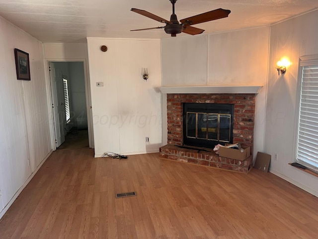 unfurnished living room featuring ceiling fan, a fireplace, and hardwood / wood-style floors