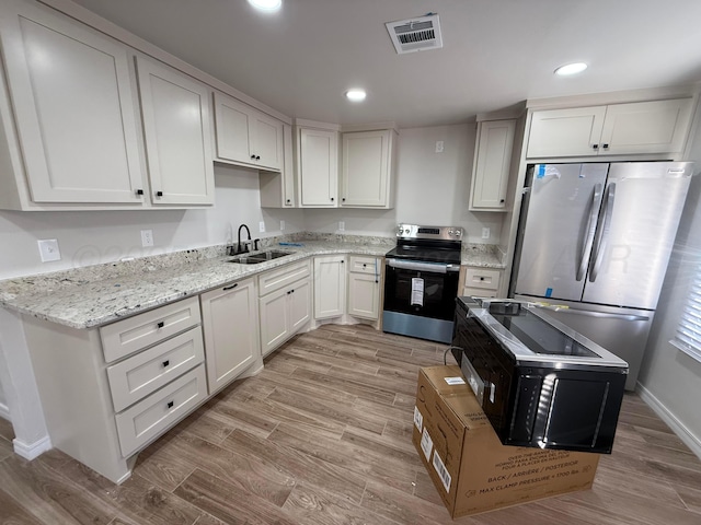 kitchen featuring recessed lighting, a sink, visible vents, appliances with stainless steel finishes, and light wood-type flooring