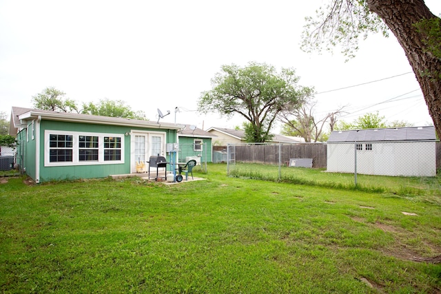 view of yard featuring fence, a patio, central AC unit, and french doors