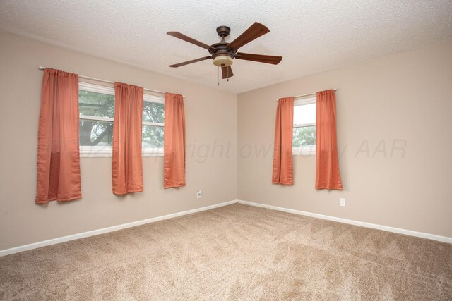 spare room with baseboards, carpet flooring, a ceiling fan, and a healthy amount of sunlight