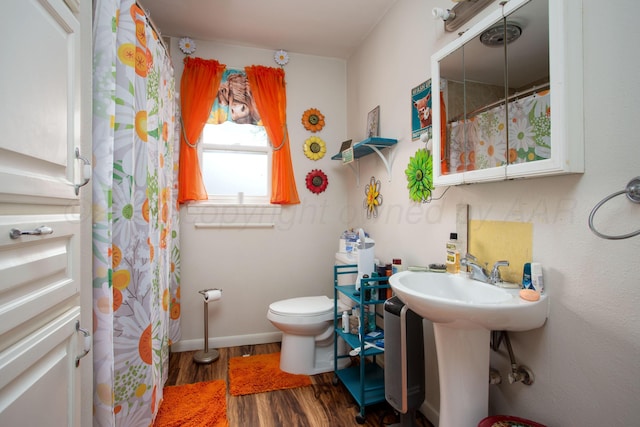 full bath with baseboards, a shower with shower curtain, wood finished floors, and toilet