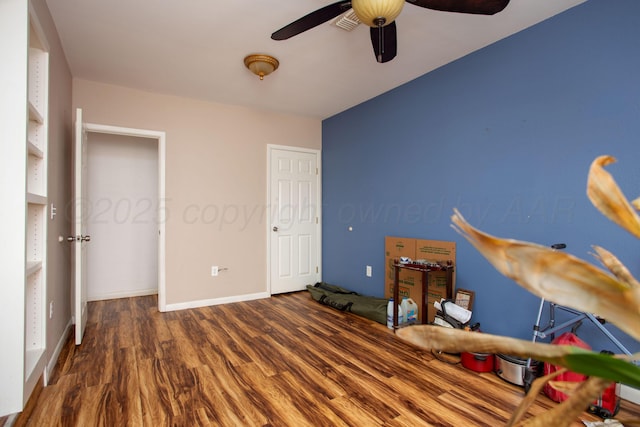 bedroom with a ceiling fan, baseboards, and wood finished floors