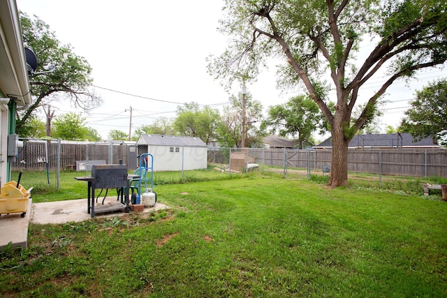view of yard featuring an outbuilding, a fenced backyard, and a shed