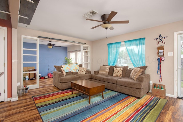 living room with baseboards, a ceiling fan, wood finished floors, and visible vents