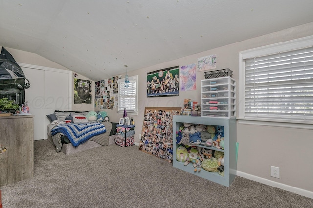 bedroom with a closet, baseboards, carpet flooring, and vaulted ceiling