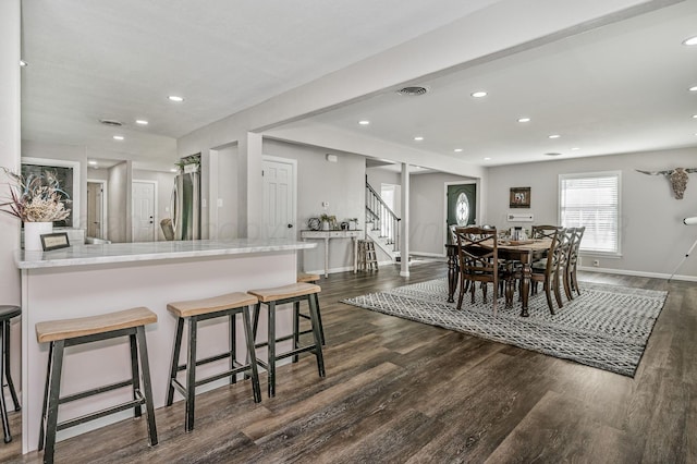 dining area with baseboards, dark wood-style floors, visible vents, and stairs
