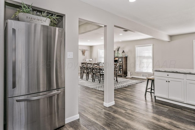 interior space featuring a healthy amount of sunlight, freestanding refrigerator, dark wood finished floors, and recessed lighting