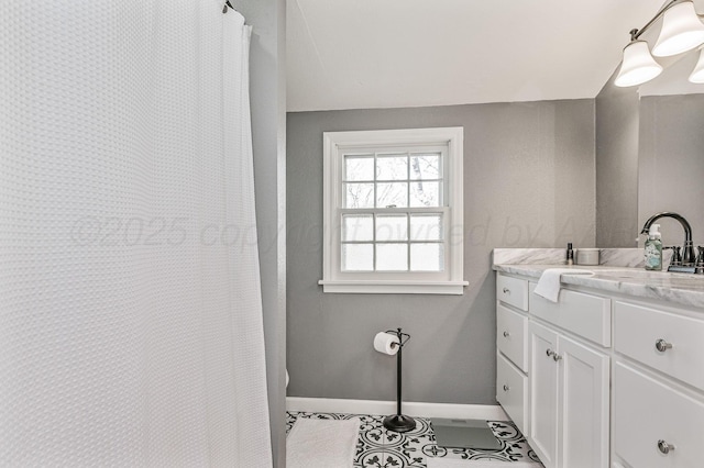 bathroom featuring vanity, baseboards, and tile patterned flooring